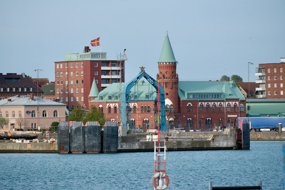 Backsteingebäude von Trelleborg Central mit grünem Turm, vom Hafenbecken aus gesehen